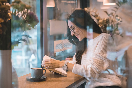 微笑着的女人在咖啡厅用咖图片