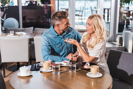 幸福的情侣握手在咖啡图片