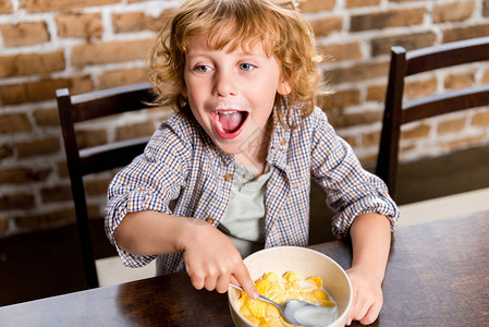 可爱的快乐的小男孩吃玉图片