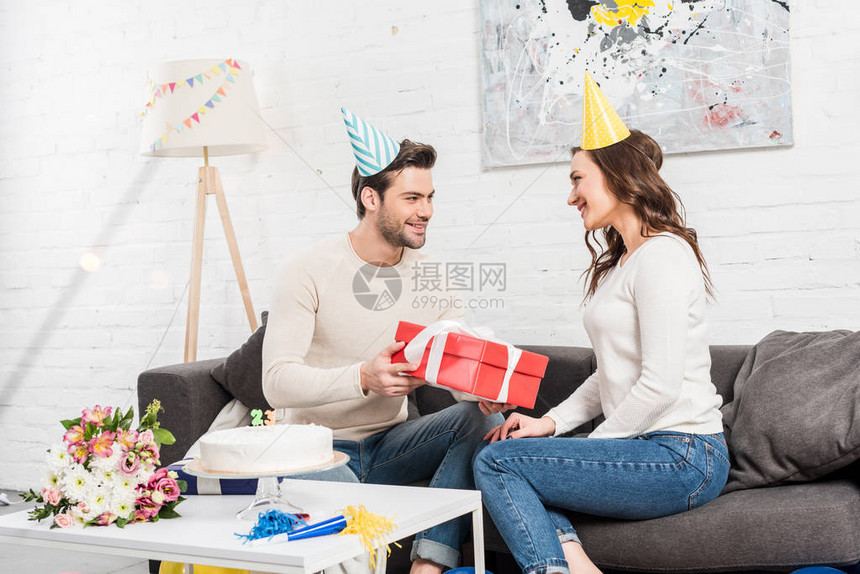 快乐的情侣庆祝生日男人在客厅里给图片
