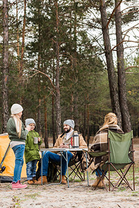 快乐的年轻家庭在森林露营从图片