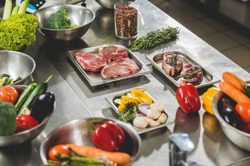 餐厅厨房餐桌上的生肉和蔬菜图片