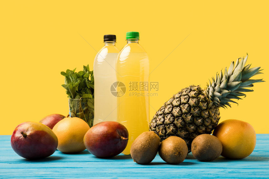 用塑料瓶装的果饮料和绿木桌顶上的成熟热图片