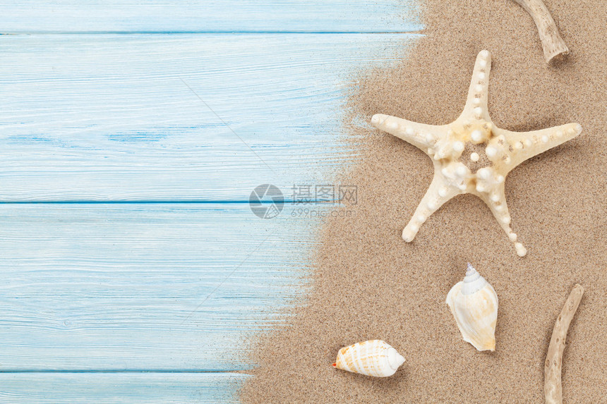 木桌上有海星和贝壳的海沙带复制空间的顶视图图片