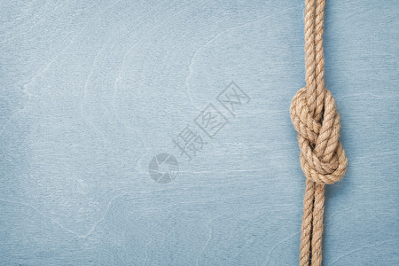 蓝色木质背景上的绳结图片