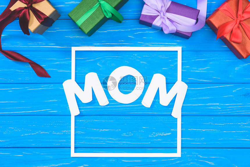 礼物盒和蓝桌框中的妈字词母亲日概图片