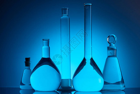 在蓝色化学实验室中装有液体的不同玻璃瓶图片