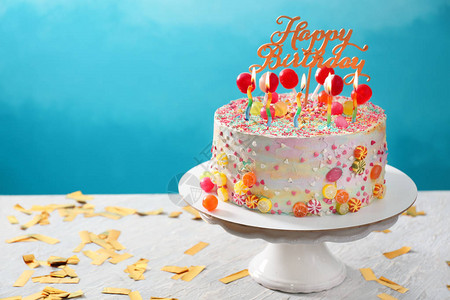 与美丽的美味的生日蛋糕站在桌边以彩色图片