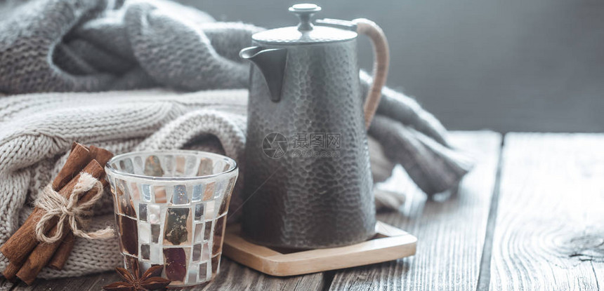 客厅内部的木桌上摆着家居装饰品茶壶和一杯茶图片