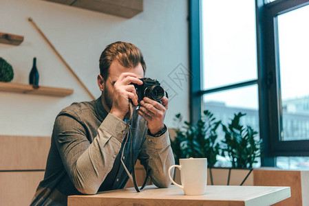 男人在咖啡馆照相机上拍背景图片