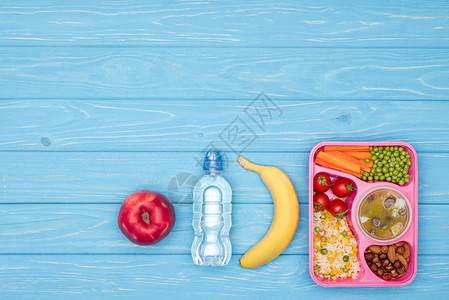 儿童午餐瓶水和蓝桌水果的餐盘风景与孩图片