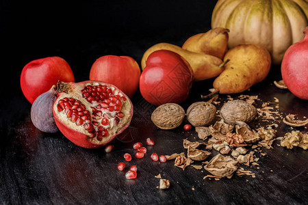 木桌上有机秋季水果和核桃的静物图片