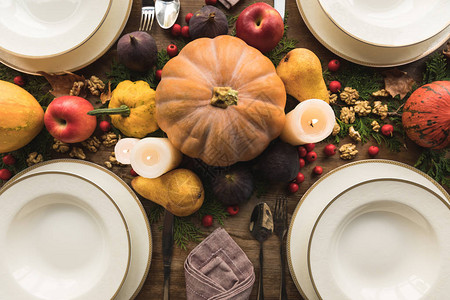 餐桌上的餐具蜡烛和秋季装饰的顶视图图片