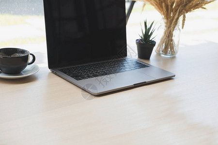 电脑笔记本植物锅咖啡杯放在木制桌子上背景图片