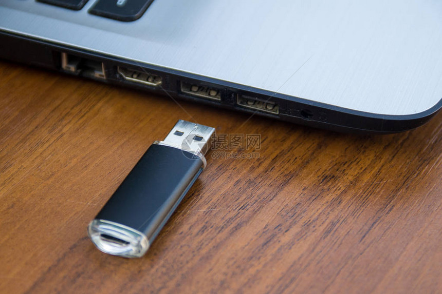 USB记忆棒或闪光驱动器以及木制桌上的图片