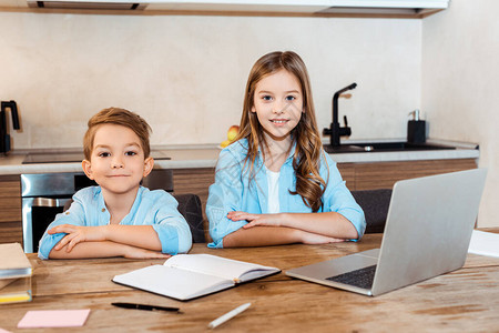 在家电子学习时坐在笔记本电脑旁边的幸福姐妹和兄弟图片