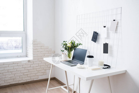 时尚的白色专业办公室内部有桌笔记本电脑和情绪板的最小型图片
