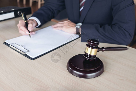 在法庭法律和司法概念的木制桌子上写有马累法官说明文件图片