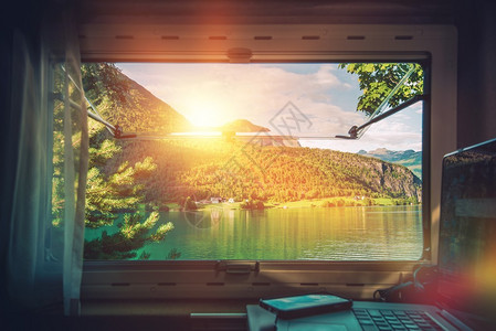 风景优美的办公桌在假期旅行时在露营车房上工作在RV摩托车内的笔记图片