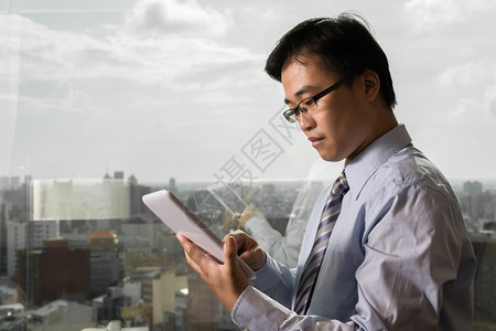 亚洲商人在办公室使用平板电脑玻图片