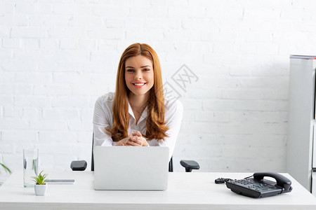 成功的商业妇女对笔记本电脑和桌上电图片