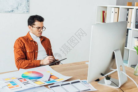 使用靠近计算机的图形平板和桌面上用户经验设计布局的英图片