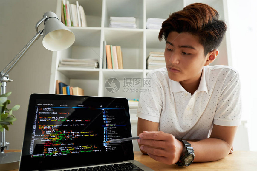 越南青年程序员在笔记本电脑屏图片