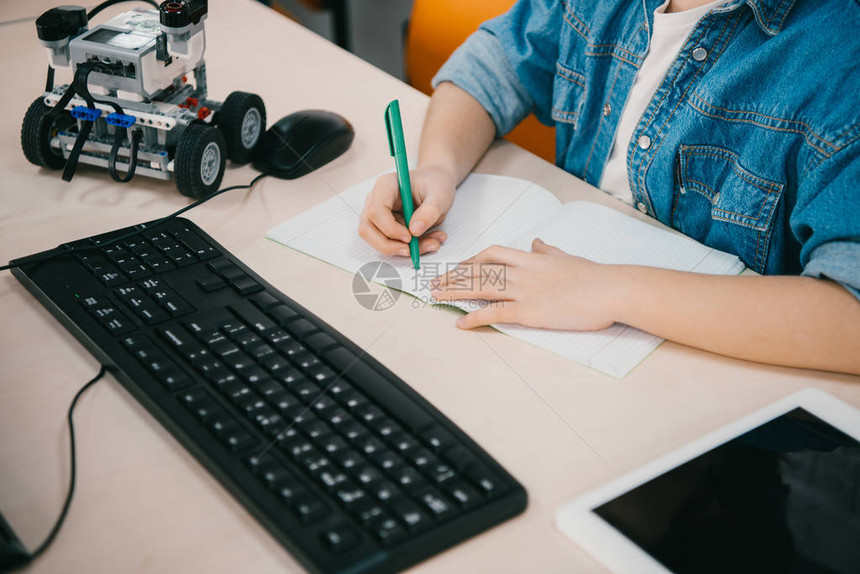 孩子在机械课上在笔记本上写字的镜头图片