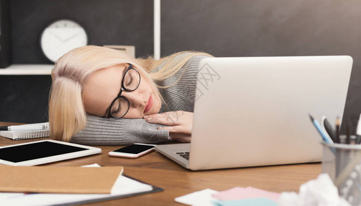 上班睡觉疲惫劳累过度的女商人在现代办公室的工作场所打图片