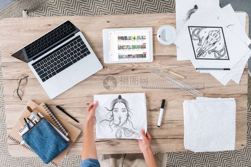 女艺术家用笔记本电脑和数字平板电脑将绘画放在桌子上的裁剪图像图片