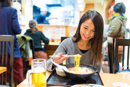 在日本餐厅吃日本拉面的女人图片
