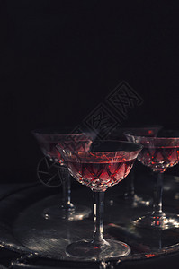 深色背景中复古水晶玻璃杯中的樱桃利口酒图片