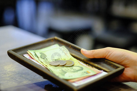与泰国货币钞票和硬币提普在餐厅现金收货变动时密图片
