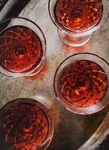 深色背景中复古水晶玻璃杯中的樱桃利口酒图片