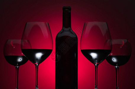 红色背景上的眼镜和一瓶红酒图片