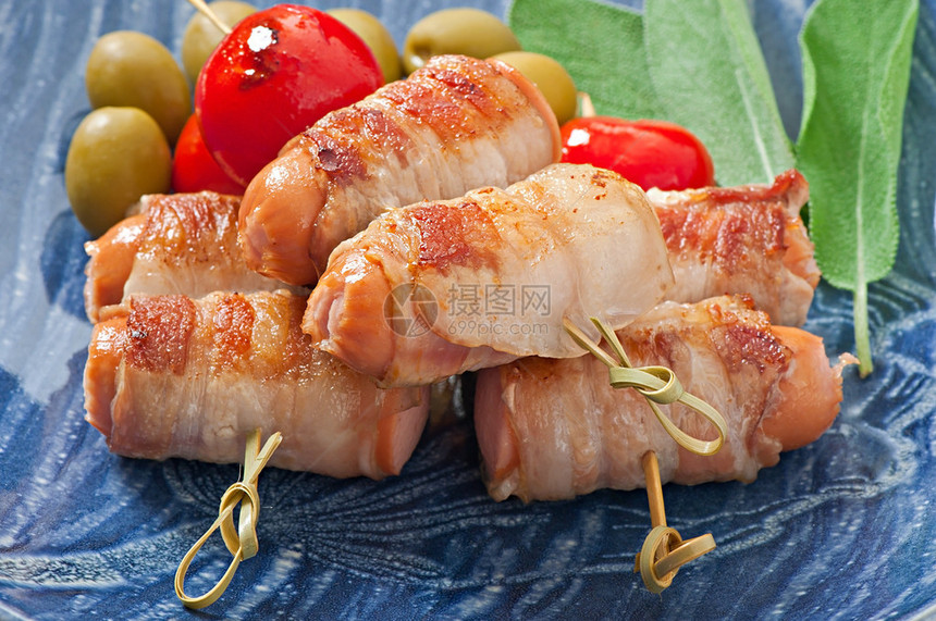 烤香肠用培根条包裹着西红柿和鼠尾草叶图片
