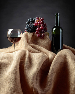 红酒和葡萄放在桌边上图片