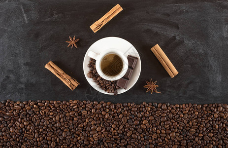 黑板上肉桂和茴香杯咖啡豆的背景图片