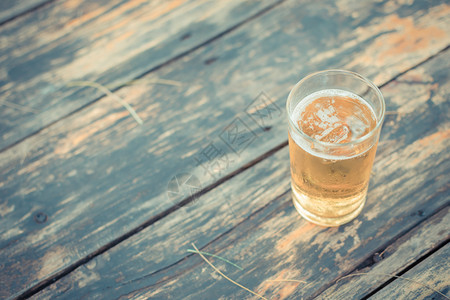 啤酒在玻璃中在木板上加冰和霜用图片