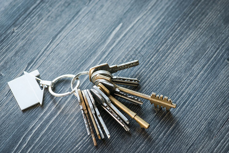 一堆钥匙和房子形状的钥匙环在生锈图片