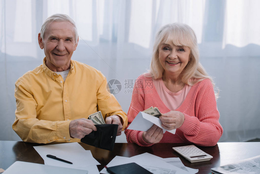 一对高龄夫妇拿着钱包和信封图片