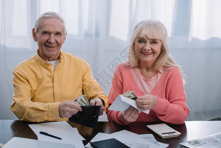 一对高龄夫妇拿着钱包和信封图片