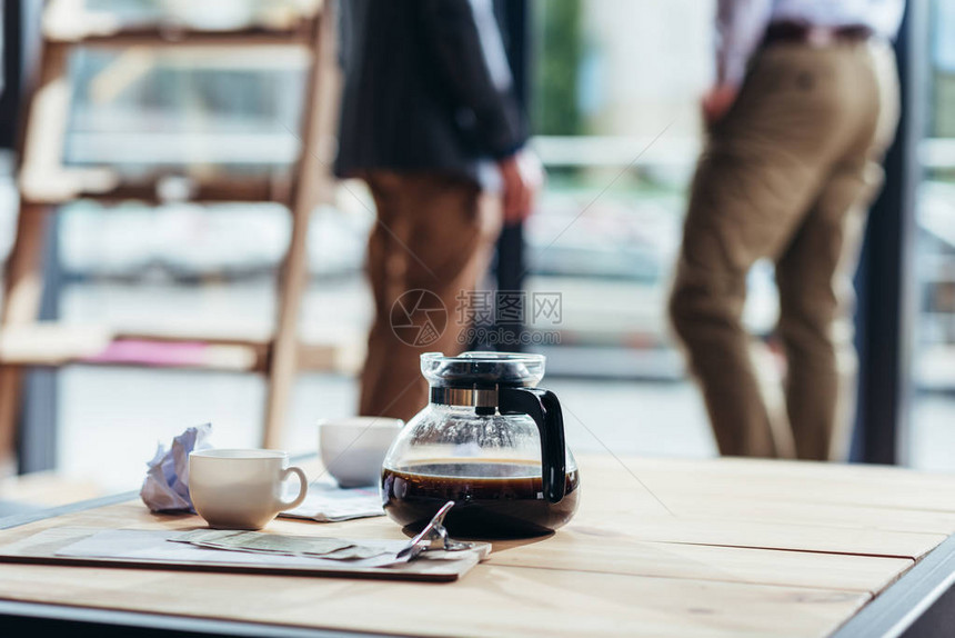 茶壶和杯子钱和木桌报纸图片