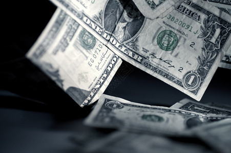 美国货币贬值一元钞票掉在桌子上黑暗背景图片