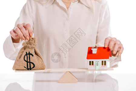 商业女商人权衡房屋模型和孤立在白色按揭概念上的货币图片