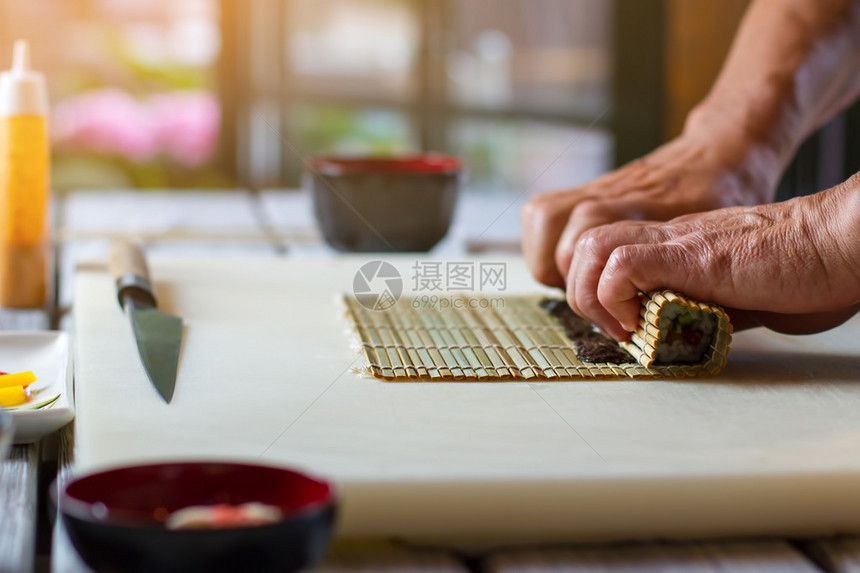 男手摸竹垫小竹垫和刀经验丰富的寿司厨师准备健图片