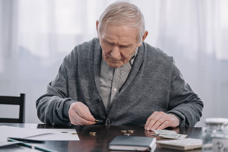 老人坐在桌前在家数钱图片