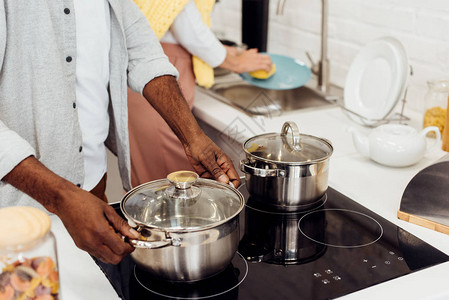 非洲裔美国男人拿着锅女人在厨图片