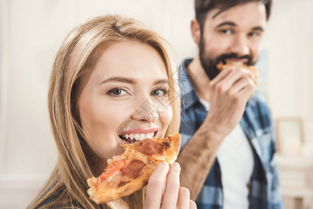 在家吃美味比萨的年轻夫妇背景图片