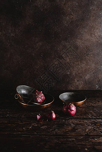 在质朴的木桌上近距离观察带有红洋葱的老式器皿图片